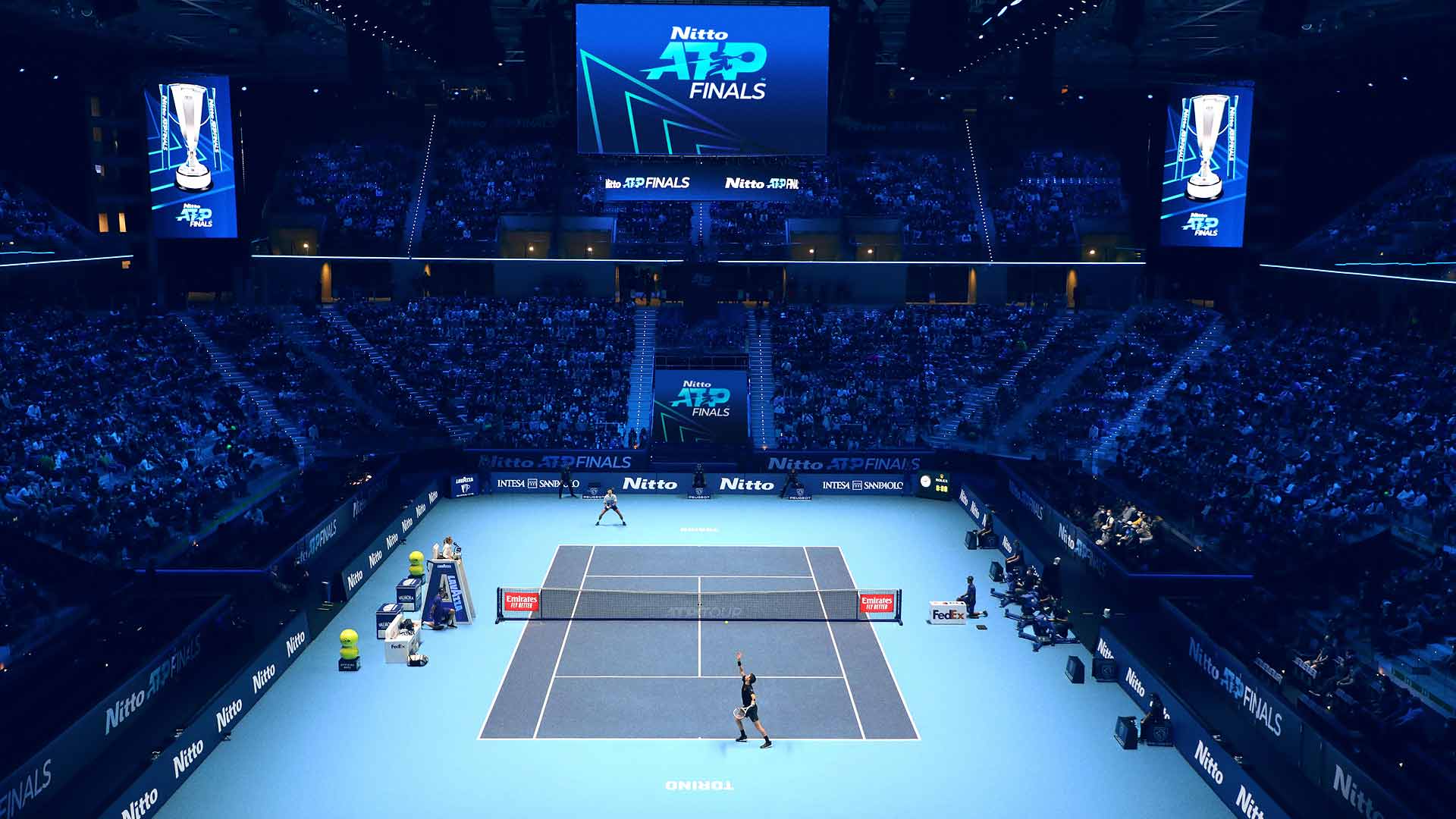 A blue indoor tennis court beneath Nitto ATP Finals signs in a packed arena