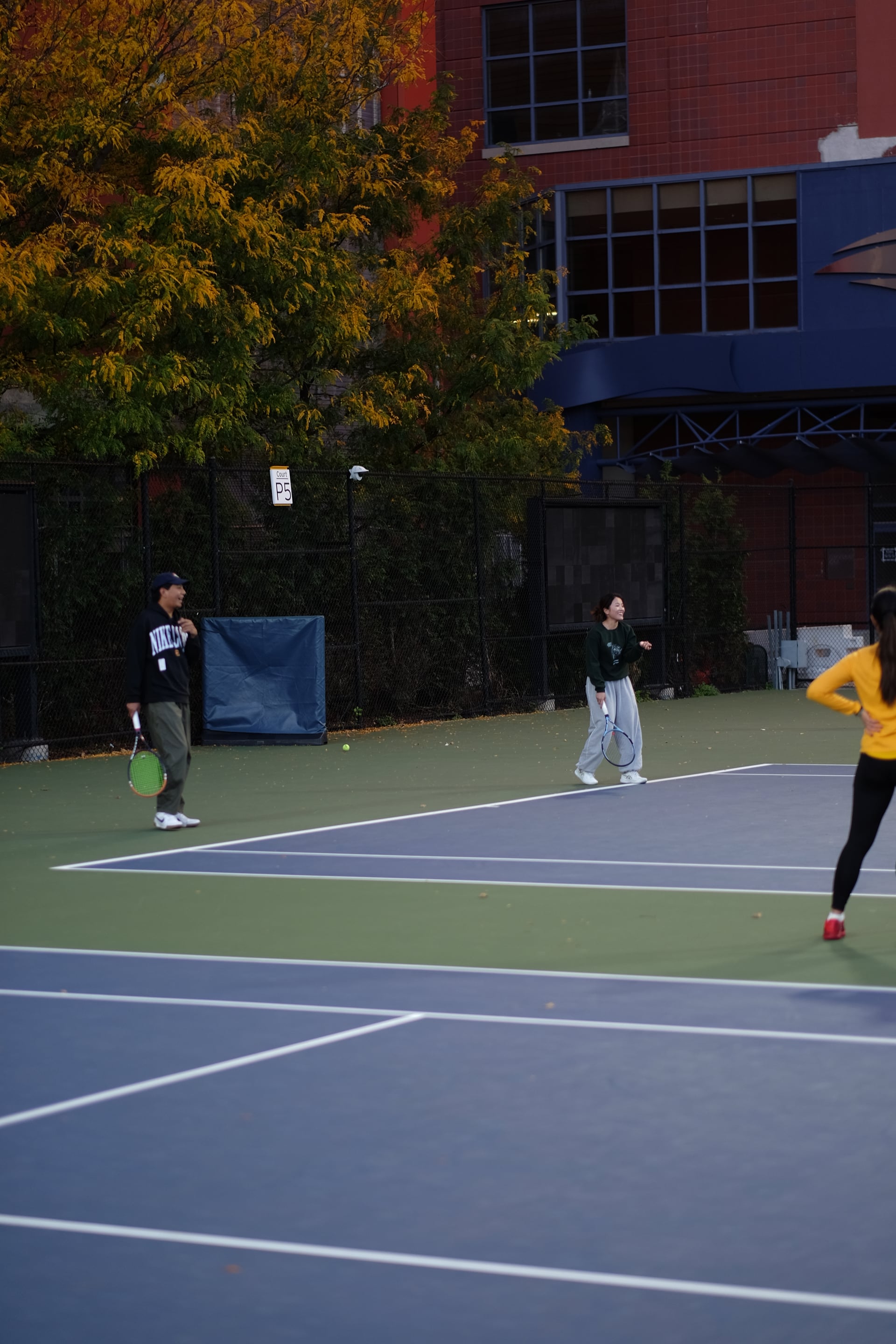 Players sharing a smile between points on practice court P5 at Saturday Sunset Club, October 17, 2026