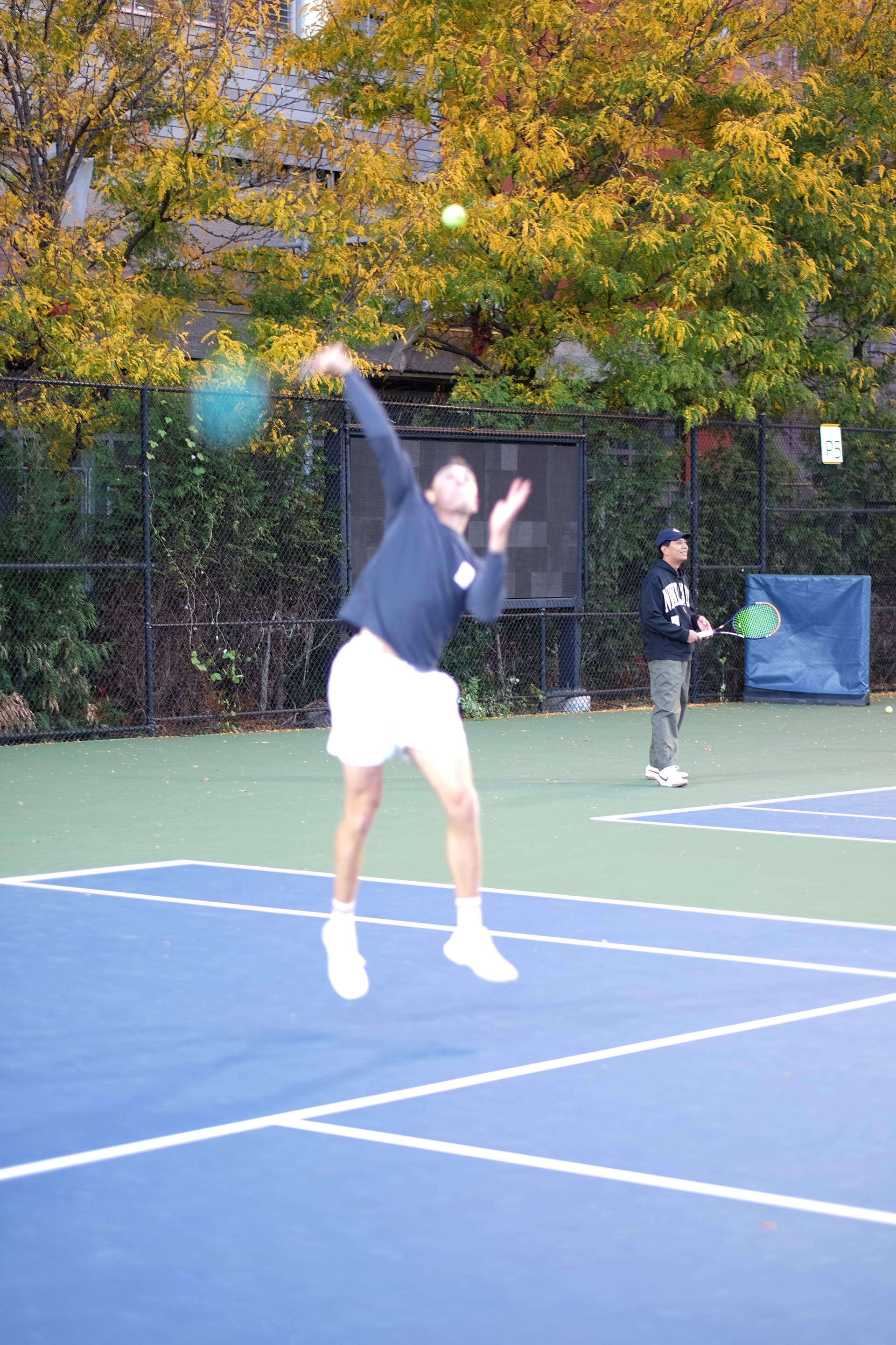 A player reaching up for an overhead as a partner watches at Saturday Sunset Club, October 17, 2026