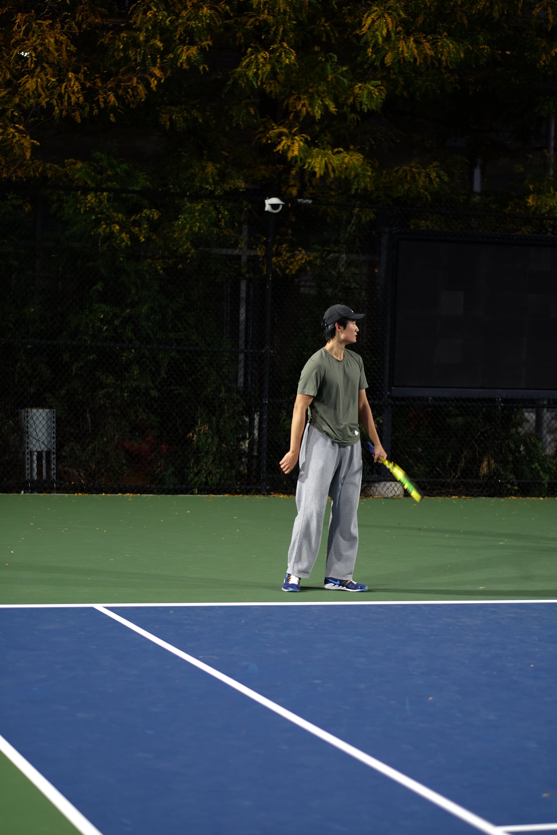A player waiting with a racquet beneath the autumn foliage at Saturday Sunset Club, October 17, 2026