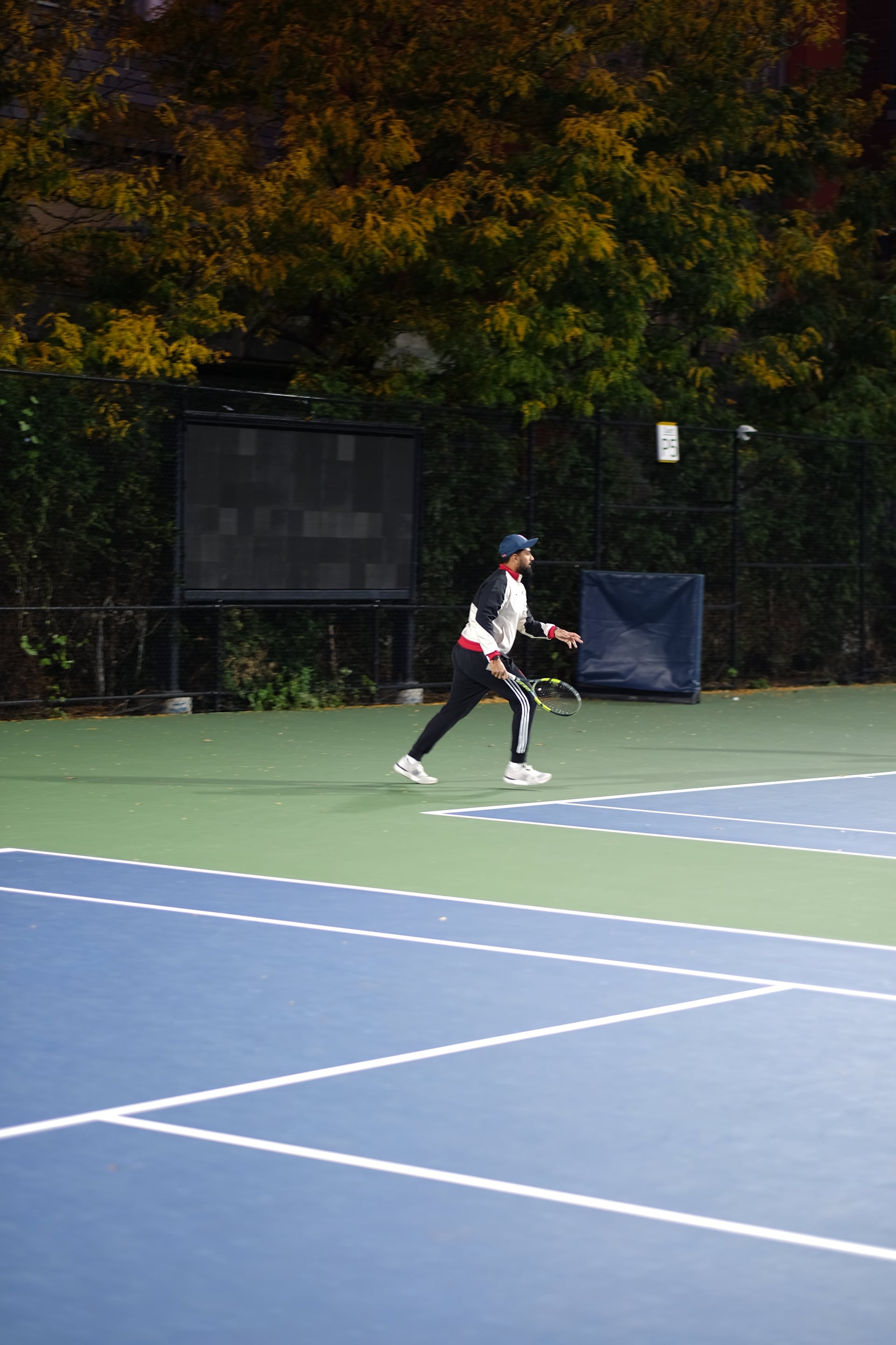 A player moving toward the net during a doubles point at Saturday Sunset Club, October 17, 2026