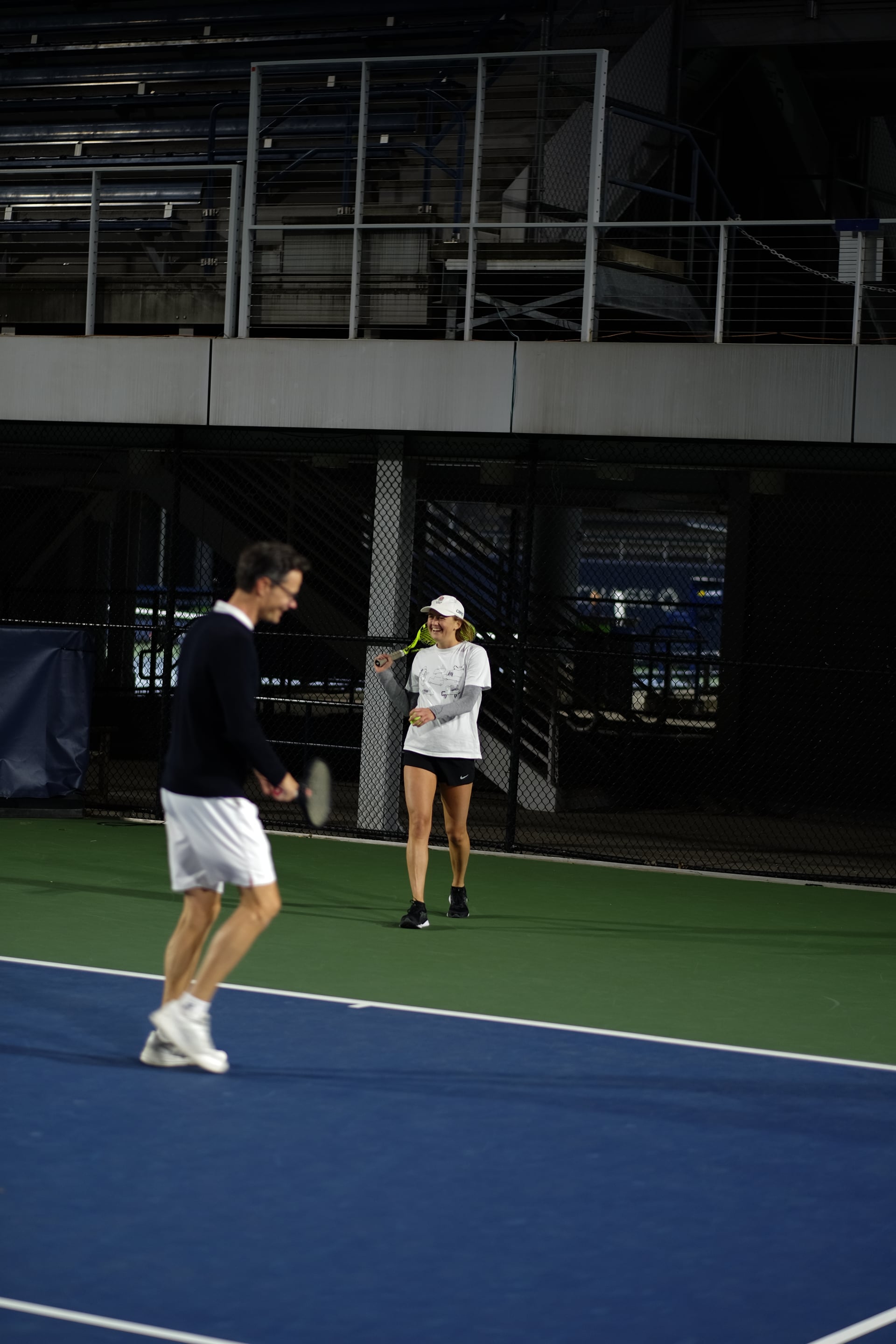 Doubles partners enjoying a break between points under the lights at Saturday Sunset Club, October 17, 2026