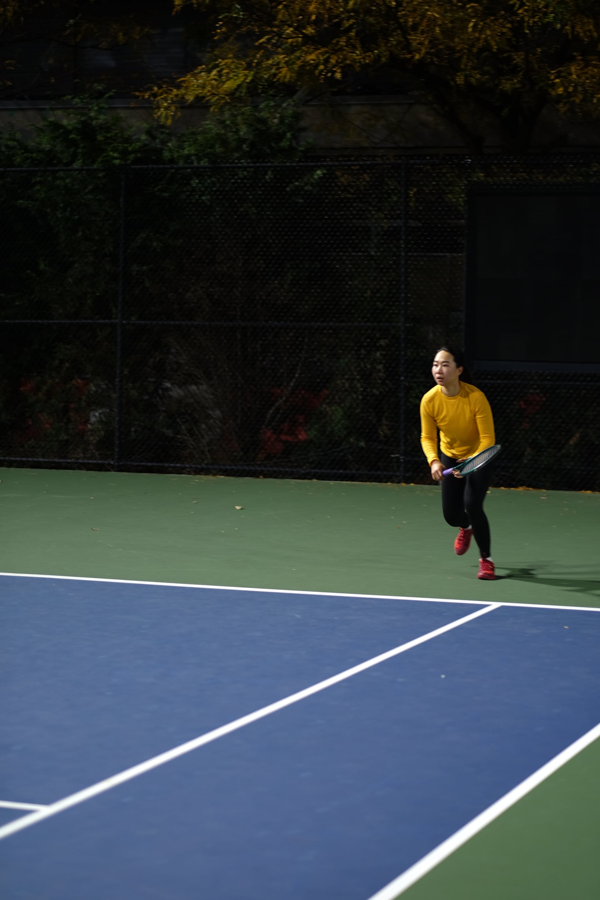A player in yellow ready to return under the court lights at Saturday Sunset Club, October 17, 2026
