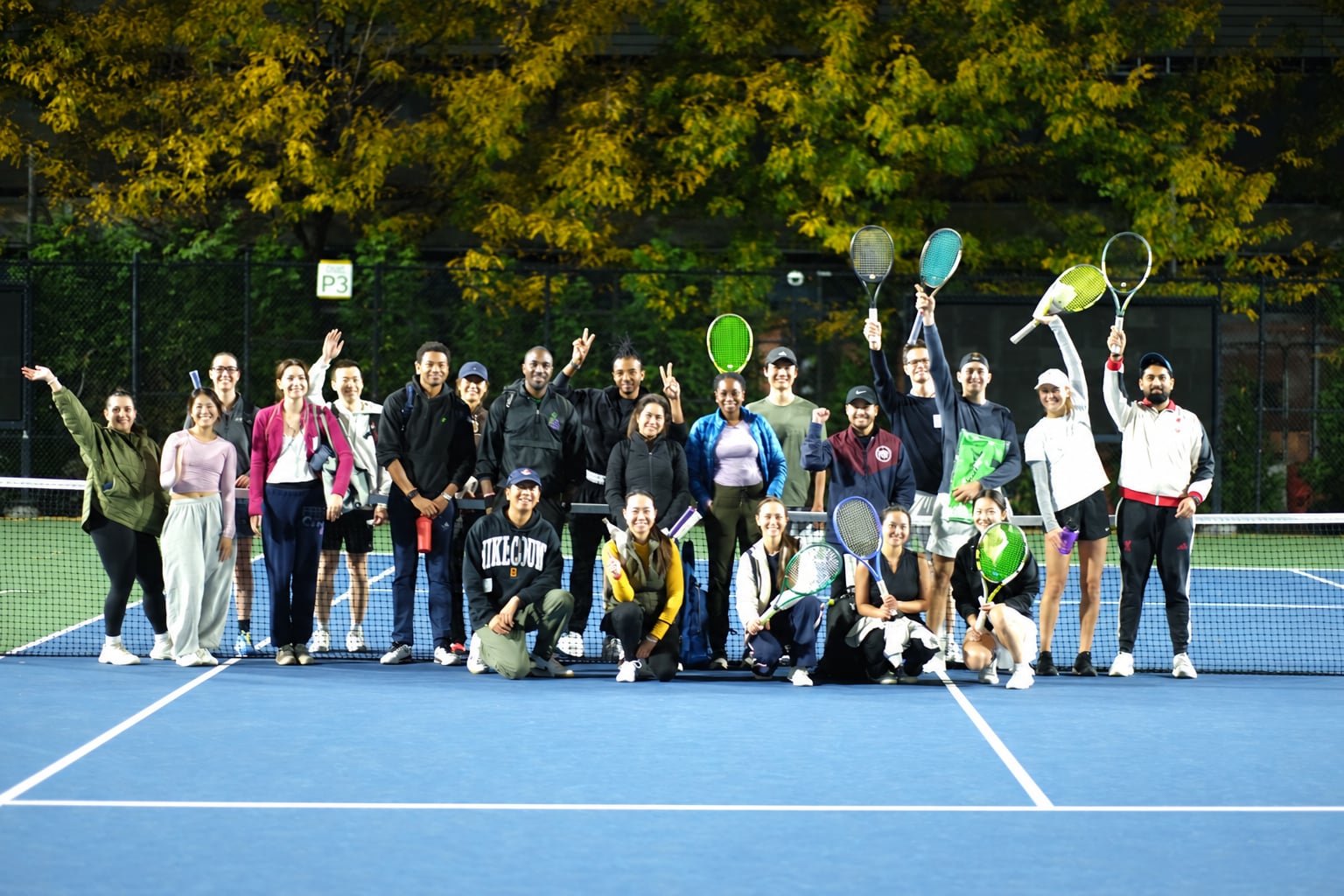 Saturday Sunset Club players together under the lights at Billie Jean King National Tennis Center