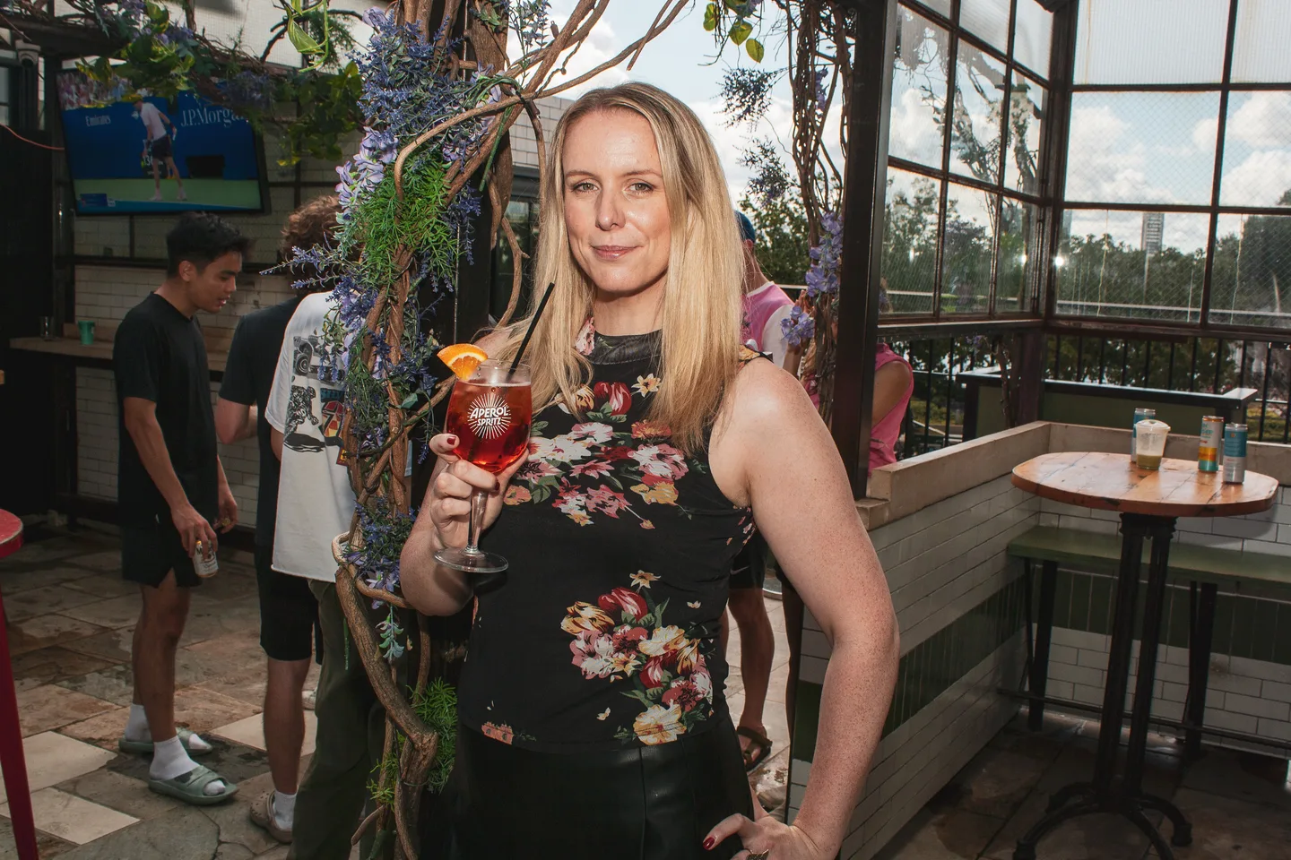Guest holding an Aperol Spritz at the rooftop watch party