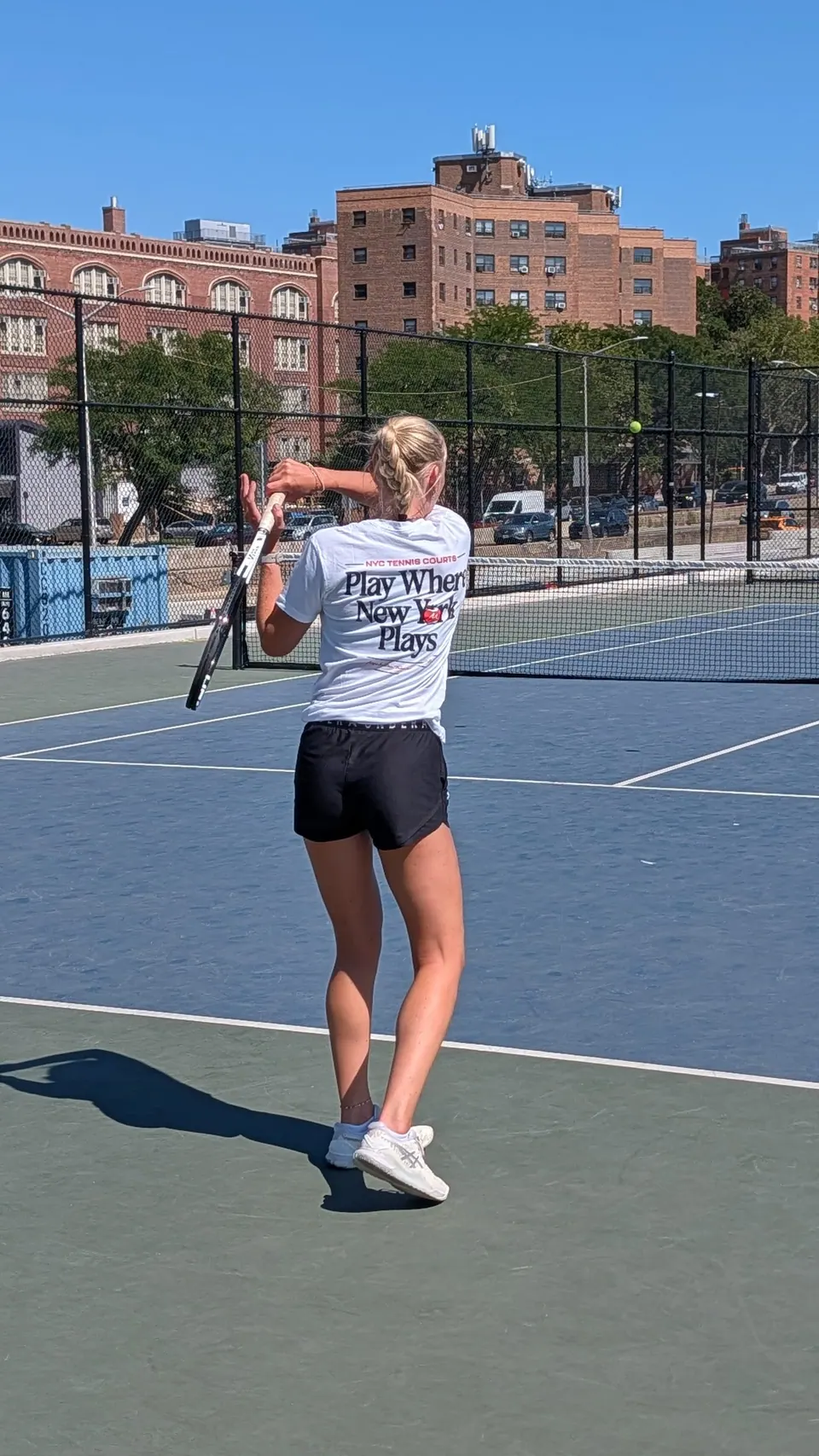 Ine following through on a forehand at Brian Watkins Tennis Center in a Play Where New York Plays shirt