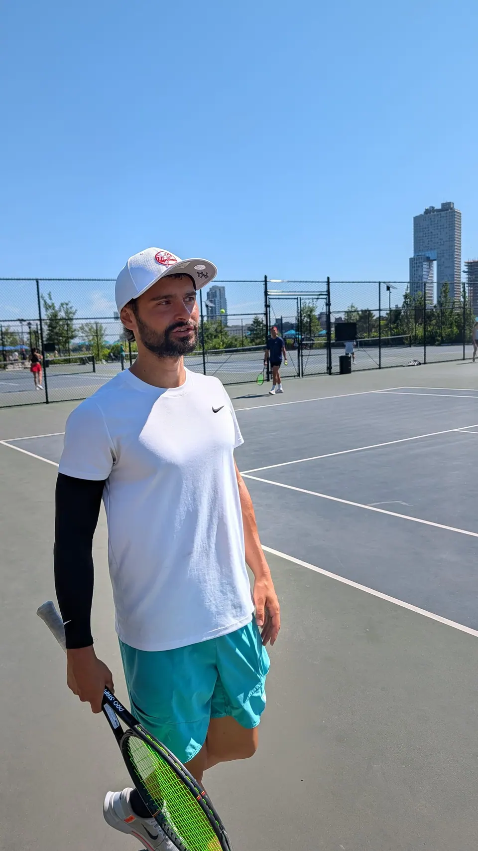 Jameson standing courtside as players warm up at Brian Watkins Tennis Center